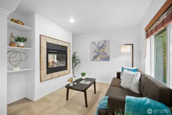 The raised sitting room has an arched room transition, gas fireplace, art niches and overlooks the back deck.
