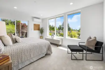 Sunlit main-level living area framed by floor-to-ceiling windows and a private fenced outlook. Photos are of model home 8825, finishes and floorplan may vary.