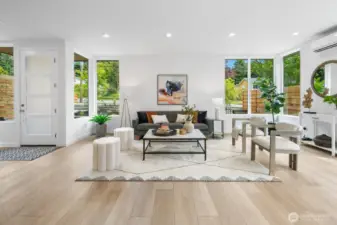Light, bright front living room with multiple seating groupings—ideal for gatherings or quiet mornings. Photos are of model home 8825, finishes and floorplan may vary.