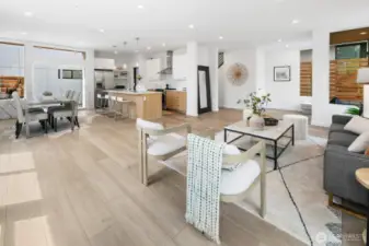 Open concept main floor—kitchen, dining, and living stitched together for clear sightlines and easy hosting. Photos are of model home 8825, finishes and floorplan may vary.