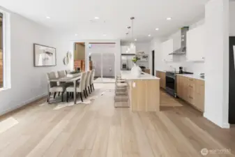 From dining toward the kitchen: indoor/outdoor potential and space to expand the table for holidays. Photos are of model home 8825, finishes and floorplan may vary.