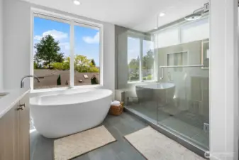 Spa-style bath upgrade: soaking tub beside picture windows plus glass shower enclosure. Photos are of model home 8825, finishes and floorplan may vary.
