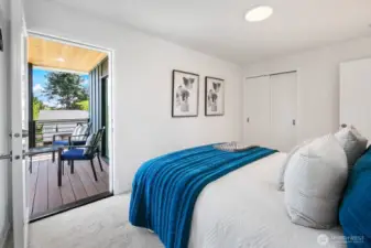 Bedroom with direct deck access—indoor/outdoor living that feels like a private treehouse. Photos are of model home 8825, finishes and floorplan may vary.