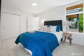 bedroom with bold blue bedding and garden views—instant pop of personality. Photos are of model home 8825, finishes and floorplan may vary.