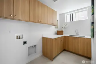 Dedicated laundry room with full cabinetry, utility sink, and folding counter keeps chores contained. Photos are of model home 8825, finishes and floorplan may vary.