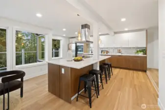 The spacious kitchen features a sunlit breakfast nook with sliding doors leading to the deck