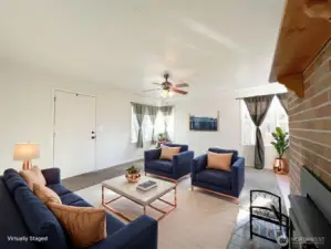 Cozy living room greets you as you walk in the door. Natural light fills the room. Virtually Staged to illustrate spatial use and scale.
