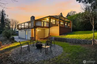 Backyard fire pit area with elevated deck and covering, offering great outdoor living in the Scenic Hill neighborhood.