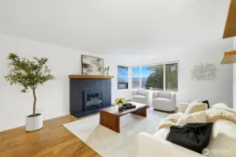 Spacious living room with fireplace and oversized windows overlooking the neighborhood.