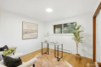 Versatile room or office space with natural light and hardwood floors.