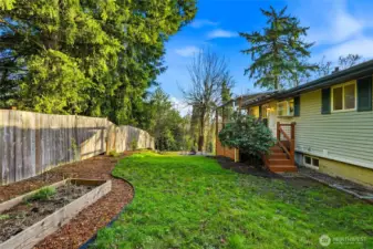 Private side yard with raised garden beds and mature landscaping.