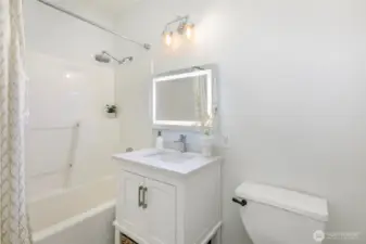 Updated bathroom features LED mirror for modern appearance and great light.