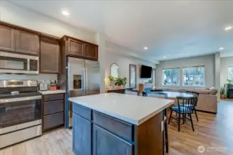 Gorgeous kitchen with large island has white Quartz counters and a space for eating.