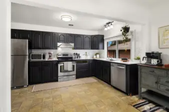 Re-finished cabinets and stainless steel appliances in this amply-sized kitchen.