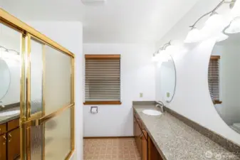 Upstairs bath has dual sinks, a tub shower combination and toilet.