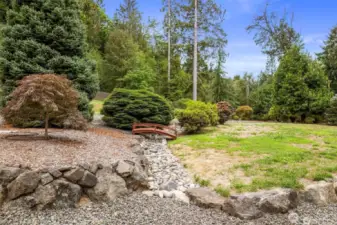 A decorative stone dry creek bed with a bridge.