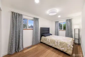 Dual windows, soft tones, and greenery views make this bedroom a restful retreat.
