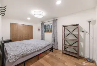 Guest bedroom with large closet, neutral finishes, and natural light.