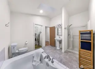 Spacious bath with tile floors, walk-in shower, pedestal sink, and walk-in closet access.