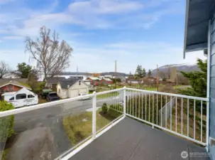 Upper-level balcony with views of neighborhood, trees, and distant mountains.