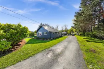 A long private driveway leads you home, bordered by mature trees and green space—offering privacy and RV parking.