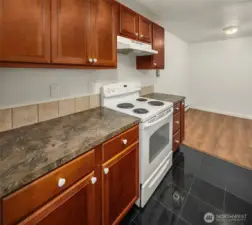 Electric range, updated cabinetry with marble tile flooring.