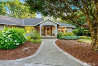 Beautifully landscaped front path leads to a covered entry, highlighting pride of ownership and curb appeal in this Maple Valley home.