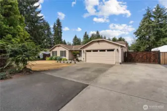 Oversized driveway with gate access and RV parking on both sides of the home.