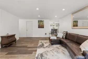 Front living room with hallway access to the left and kitchen and second living room access ahead.