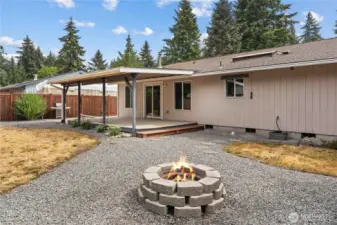 View from fire pit of the back of the home and covered patio.