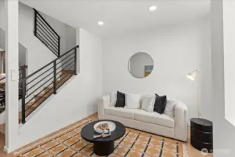 This cozy living area is anchored by clean architectural lines, warm wood floors, and oversized windows for abundant natural light.