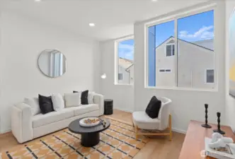 Expansive windows and a minimalist palette elevate this bright living room with stylish designer touches throughout.