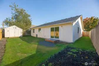 Level lot with gardening beds and outbuilding