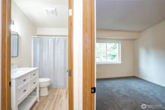 Hallway perspective leading to the primary suite and bathroom.