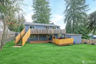 Rear exterior view highlighting the deck and a handy shed just to the right—perfect for storage or garden tools.