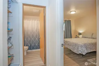 From the lower-level hallway, view the guest suite and full bath, with extra shelving conveniently located to the left.