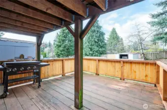 Relax on the lower-level covered deck with scenic views of the fenced backyard—perfect for entertaining or quiet afternoons.