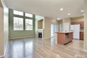 Open floorplan that is bright and light with vaulted ceiling and tall windows.