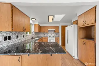 Lots of counter top space with beautiful granite and tiled backsplash.