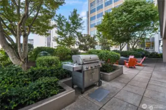 A rooftop terrace provides outdoor entertaining space with sweeping views. The Rooftop terrace of the Cosmopolitan in Seattle, offering an impressive vantage point of the city and waterfront.