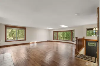 Enjoy this expansive living area filled with natural light and serene wooded views