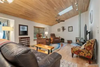 Living room w/cedar-lined ceilings, skylights, fan and window seat w/blinds