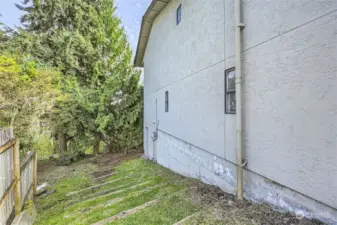 Grassy steps leading from front of home down to main backyard.