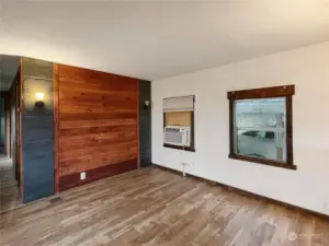 Living room boasts an eye-catching accent wall and durable laminate floors.