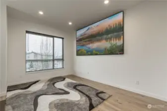 The family room is spacious, and has can lighting and vinyl plank flooring