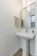 The main floor's 1/2 bath powder room, with a stylish and space efficient pedestal sink