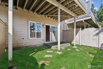 Walk out patio from basement. Grass is enhanced in photo