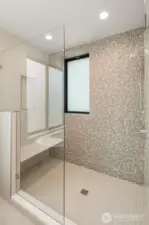 The primary suite includes a spacious walk-in shower. Tile color will vary