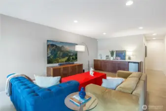 Family room with built in storage/entertaining sideboard with wet bar and beverage fridge.