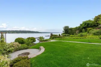 Large lawn area with stone fire pit.